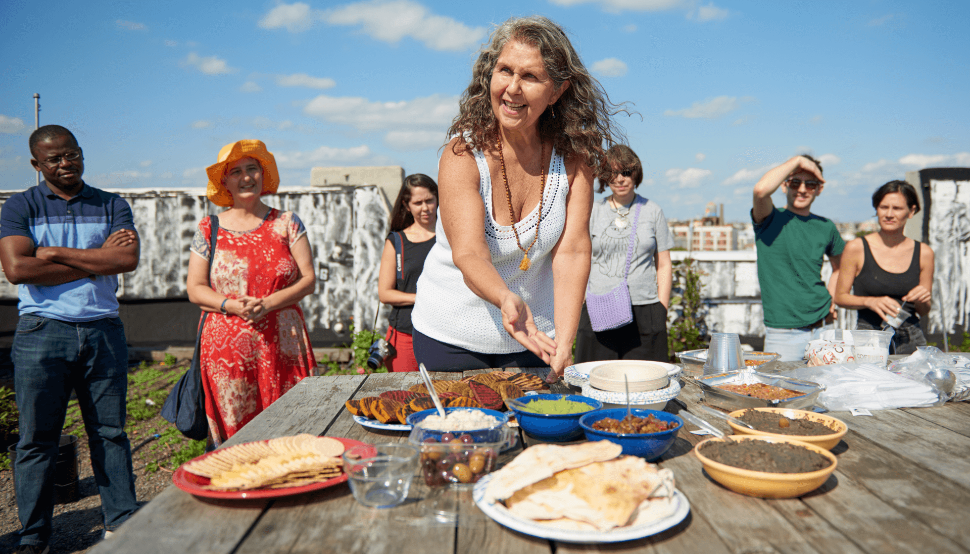 Image of woman presenting a table full of food